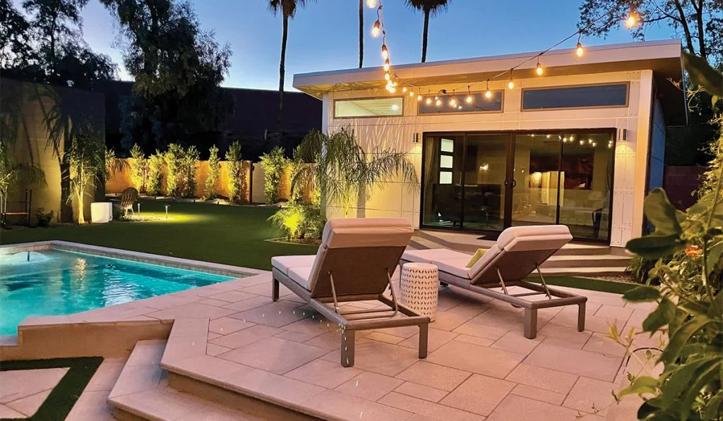 Detached accessory dwelling unit beside a pool at dusk