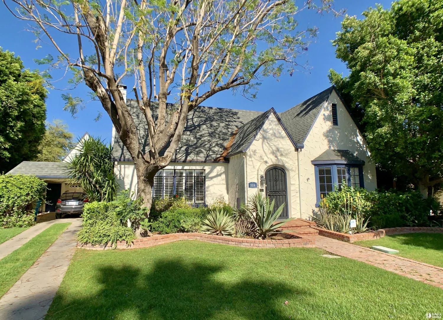 Light-colored historic home with steep gables and shaded lawn in the Encanto–Palmcroft collection