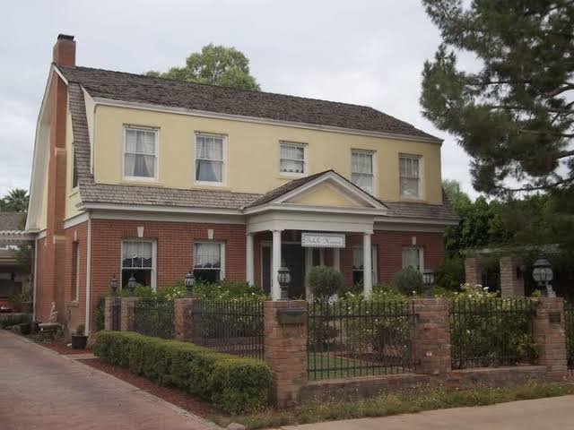 Two story Roosevelt house with brick lower level and columned front porch