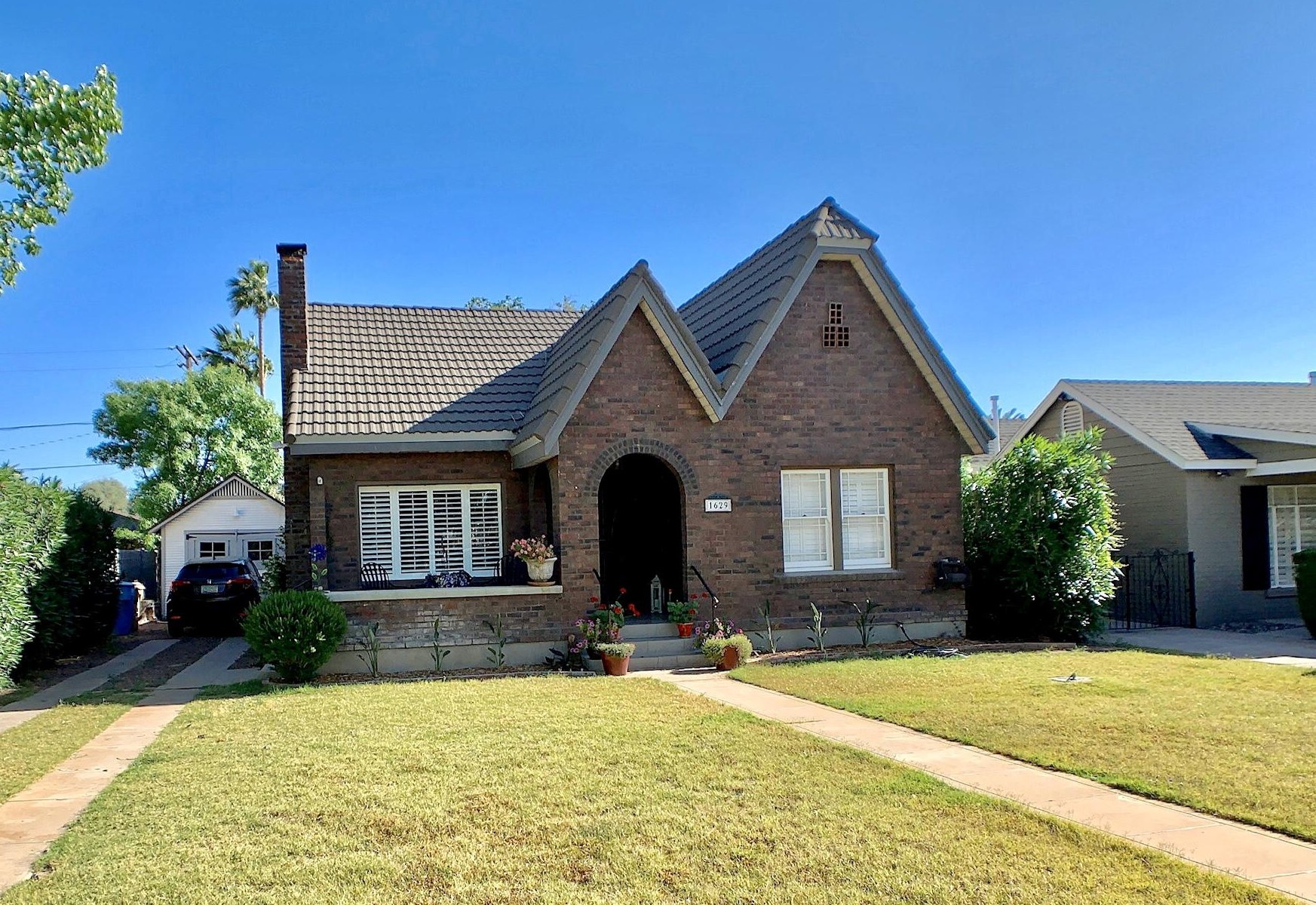 Brick cottage with steep front gables and an arched entrance