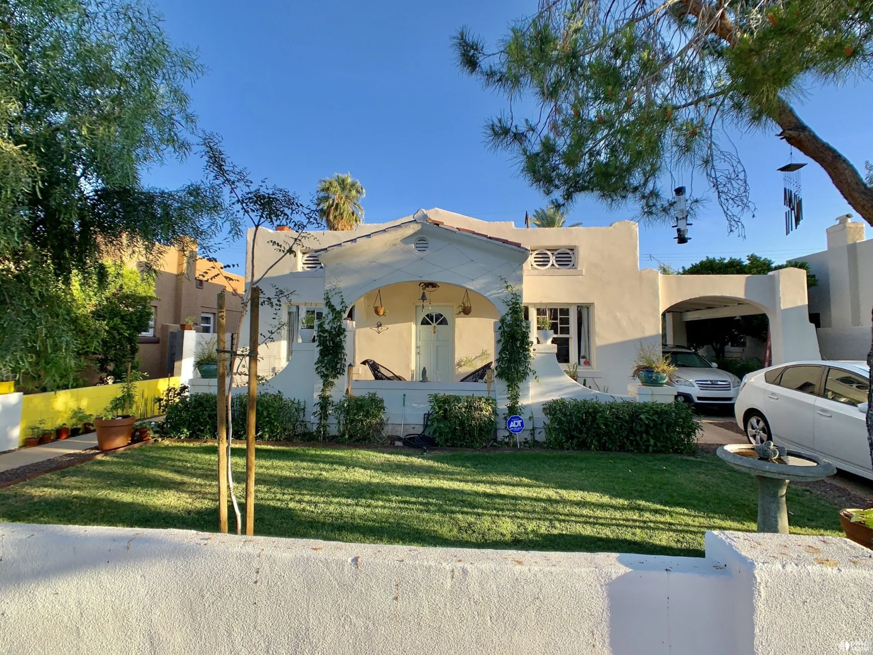 Stucco house with an arched front porch and sheltered side parking