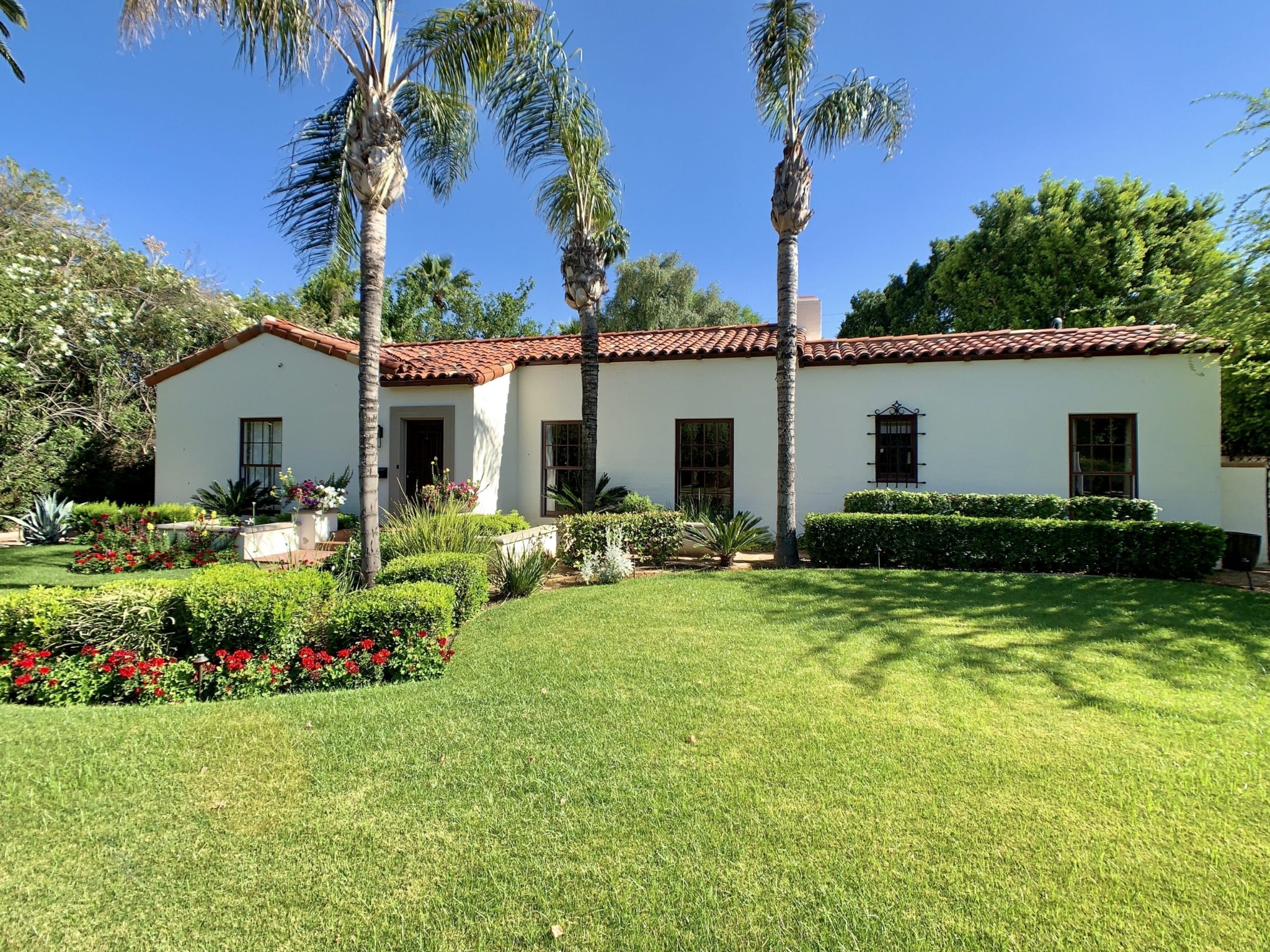 One story stucco Encanto Palmcroft home with red tile roof and palms