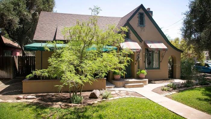 F Q Story cottage with prominent gable and landscaped entry path