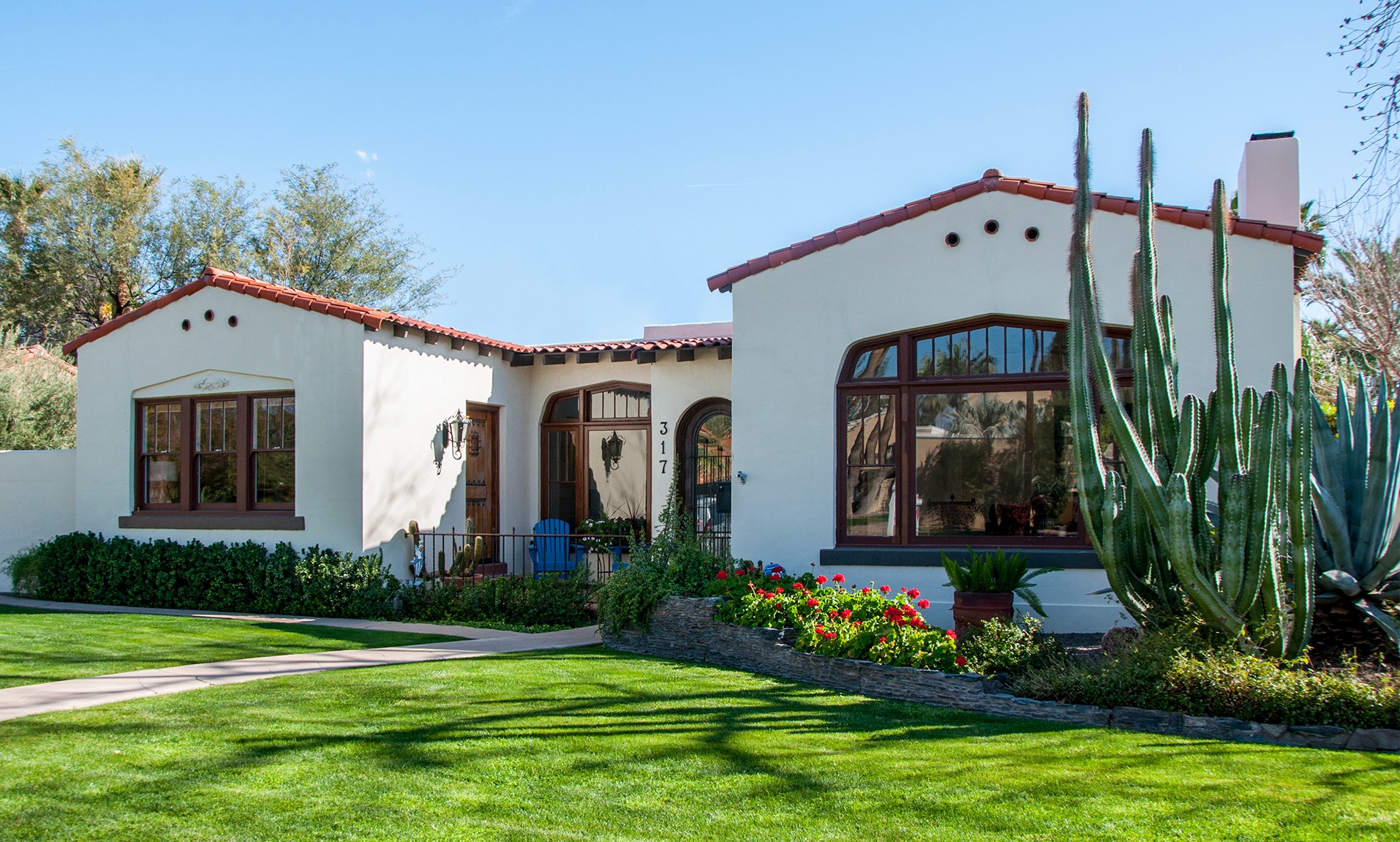 White stucco house with red tile roof and a wide arched window