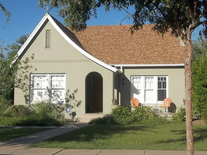 Period revival cottage with curved front gable and arched entry
