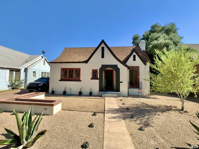 F Q Story cottage with steep front gables and dark arched entry