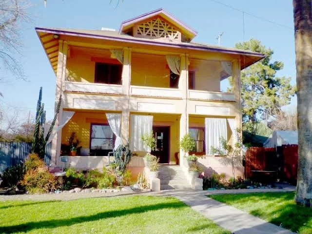 Two-story home with stacked porches and decorative gable lattice