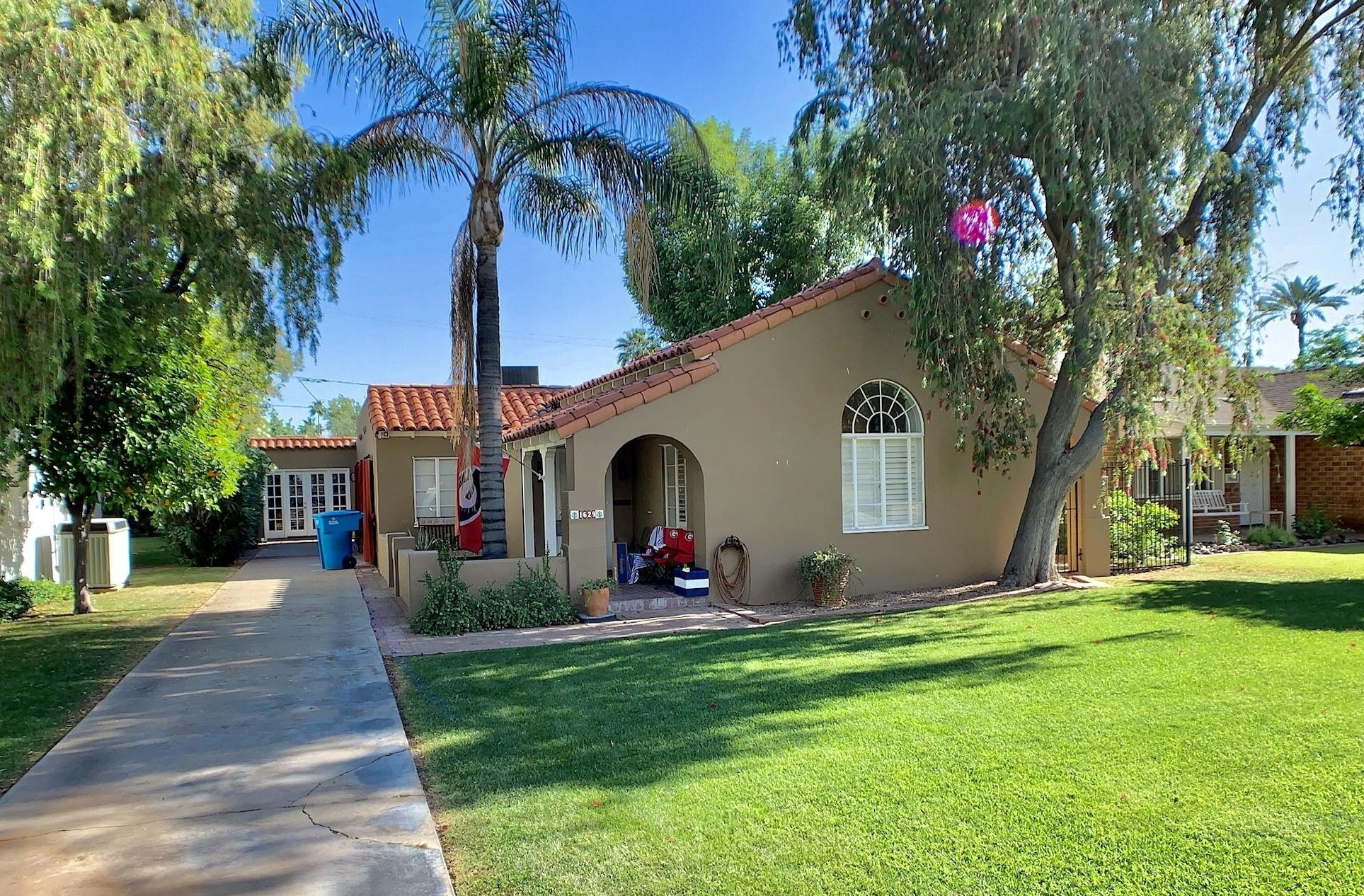 Stucco house with tile roof, arched porch and half-round window
