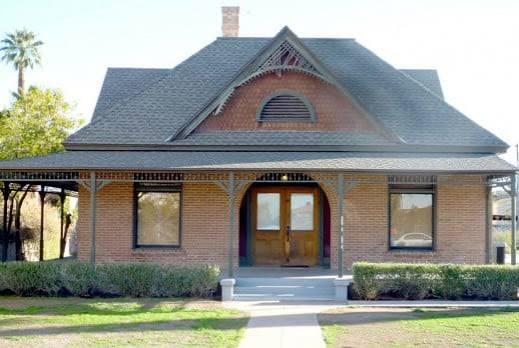 Red brick Garfield residence with roof dormer and arched doorway