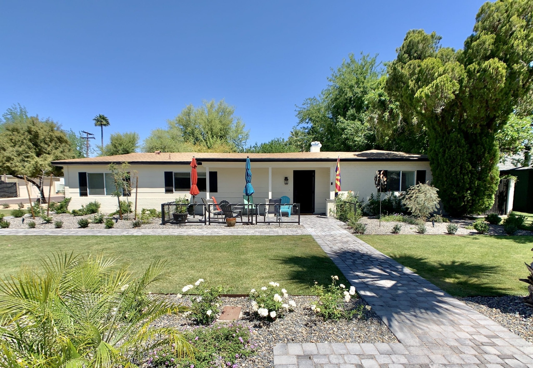 Low-slung single-story Windsor Square residence with shaded porch and large lawn